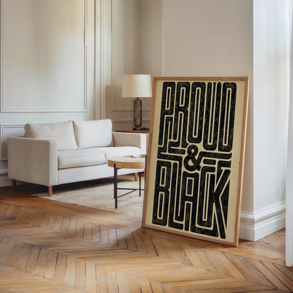 Tall Proud and Black poster placed near a modern sofa, hardwood floor, 70s black wall art statement in room