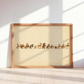 Framed woodland animal Christmas print leaning against wall, sunlit cream background, wooden frame