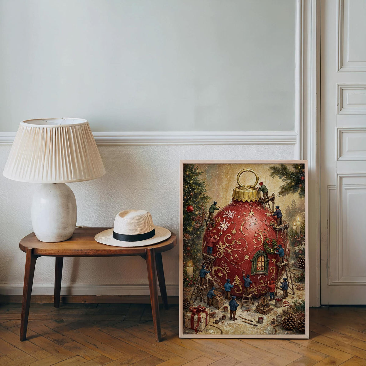 Storybook Christmas art leaning against a muted wall by a lamp, textured paper, miniature figures around bauble.