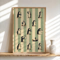 Framed penguin bathroom wall art leaning on a wooden shelf, sage green stripes, ceramic vase and sunlit shadows