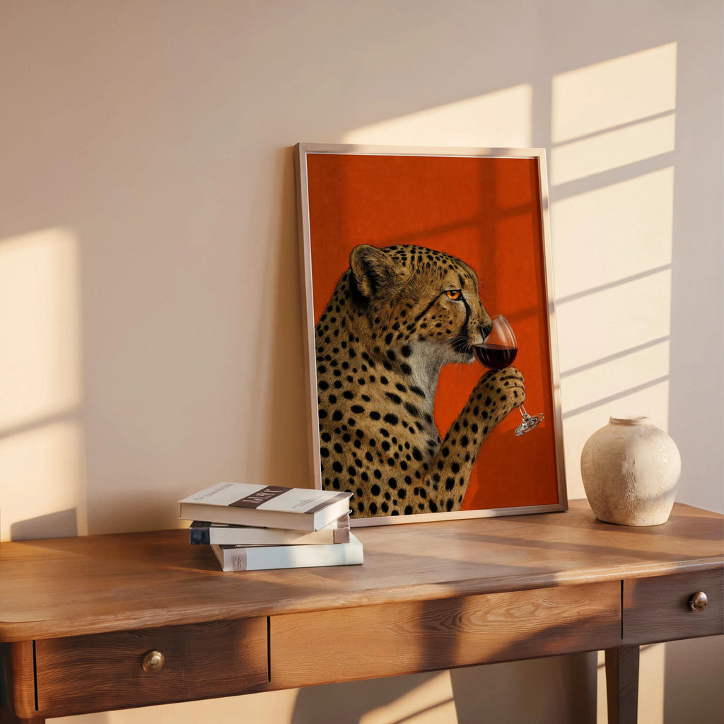 Cheetah drinking wine wall art on a wooden desk with books, maximalist red wall art that suits eclectic gallery walls