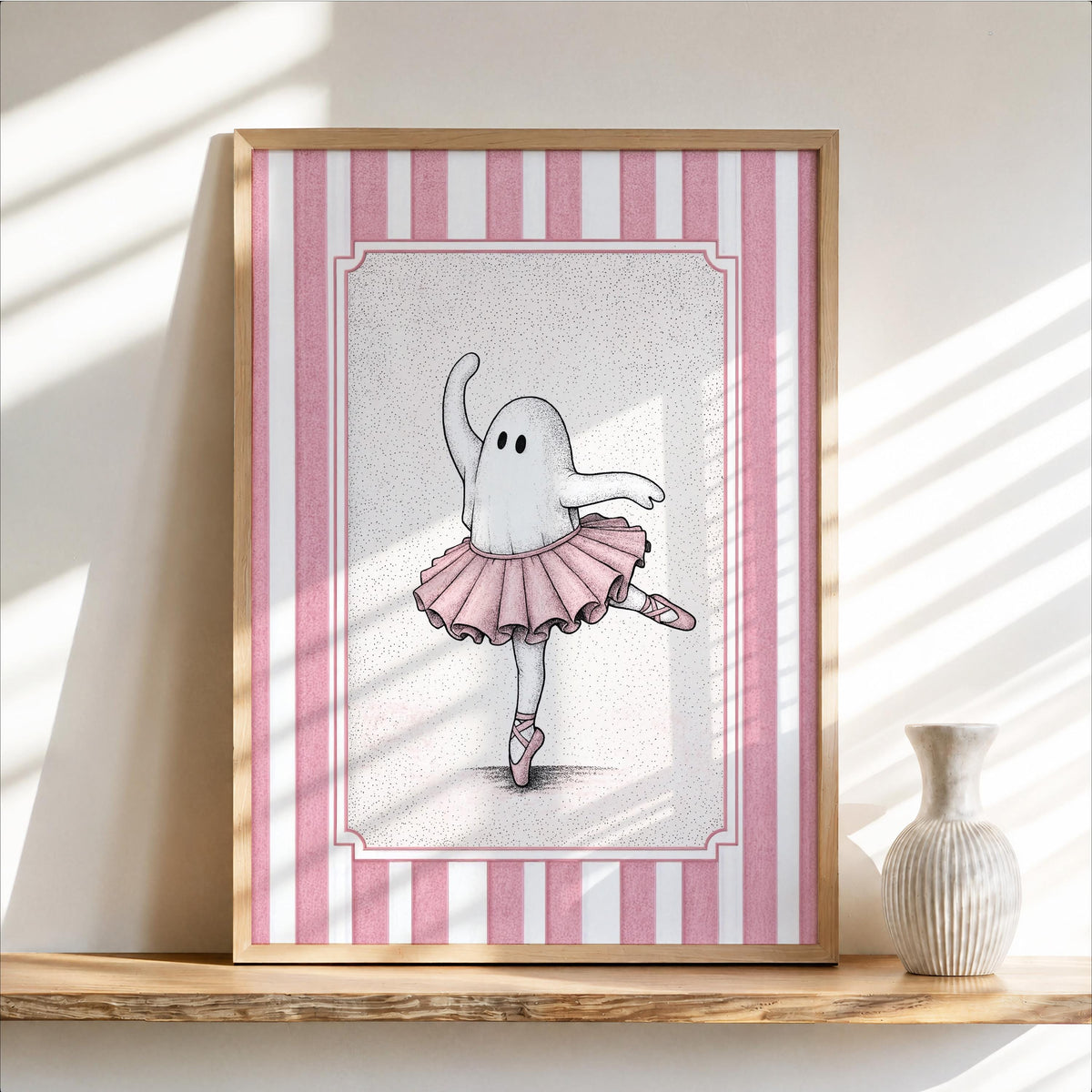 Framed ballerina ghost poster leaning on a sunlit shelf, pink-striped border and delicate tutu details