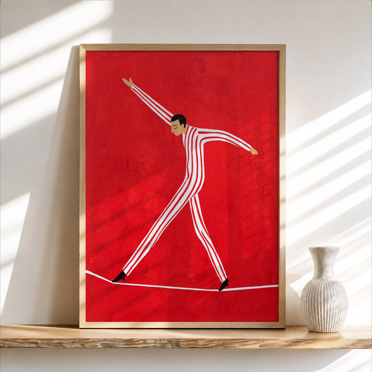 Framed light wood tightrope walker wall art on shelf, vivid red background, playful acrobat lines