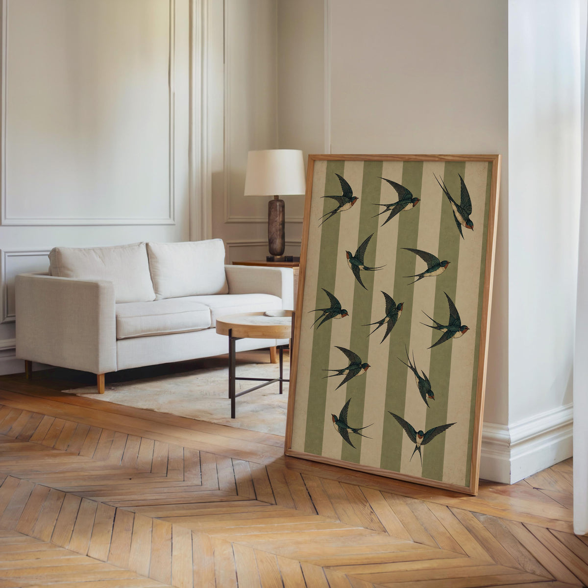 Tall framed swallow bird wall art leaning in a bright living room, retro bird poster with sage green stripes