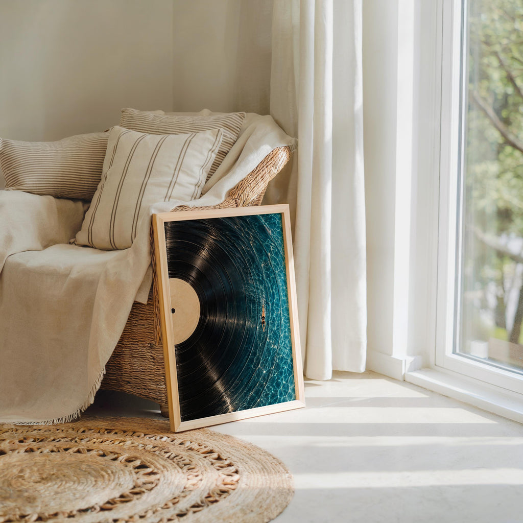 Two vinyl record wall art prints stacked by a cozy armchair and woven rug, swimmer art print duo styled