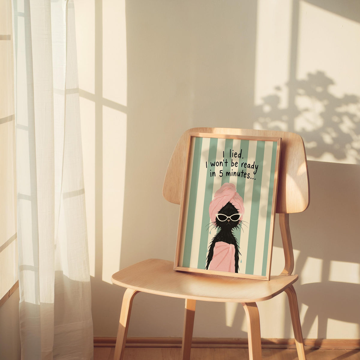 Quirky framed print perched on a wooden chair, mint stripes, white sunglasses on a drenched black cat