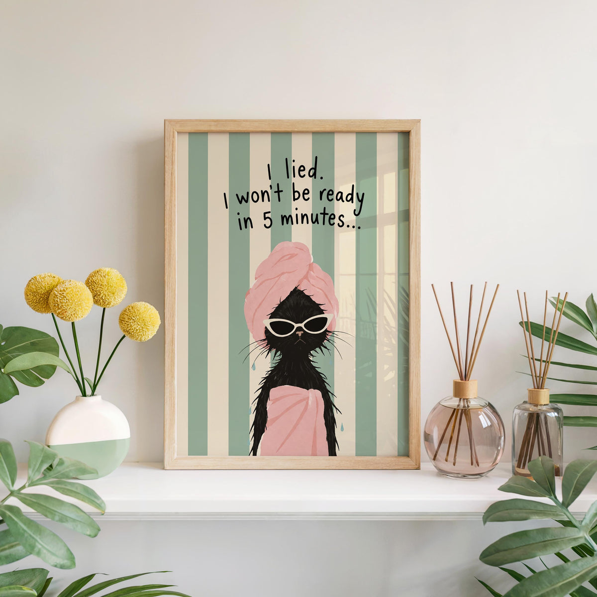Black cat art print leaning on mantel, oversized white sunglasses, playful bathroom wall decor
