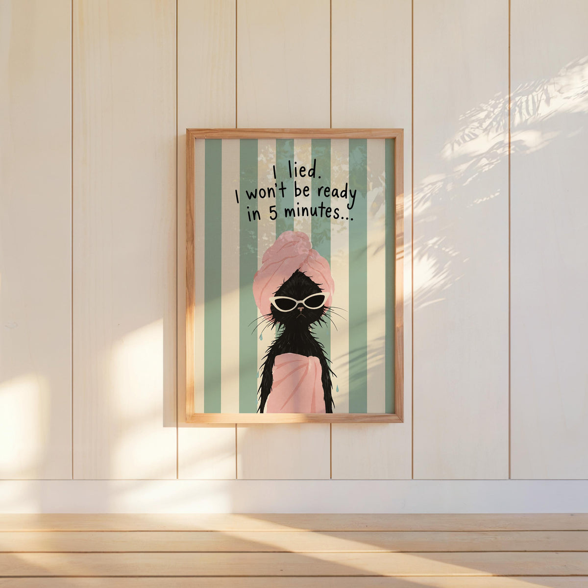 Black cat art print hung on paneled wall, mint and cream stripes, sunlit quirky bathroom decor
