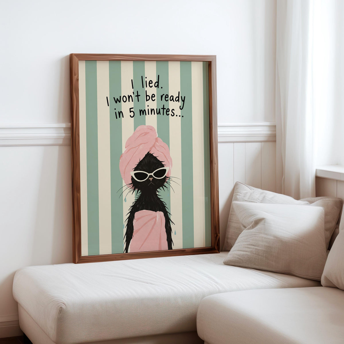 Framed funny black cat bathroom print over sofa, cozy pillows, retro mint stripes and soft pink towel details