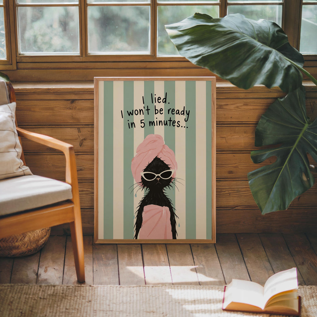 Quirky bathroom poster resting against wood console, green plant beside, vintage mint and pink palette