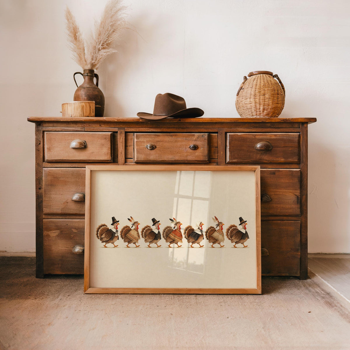 Vintage turkey print propped at a rustic dresser, small turkeys with hats and patterned wraps, warm browns