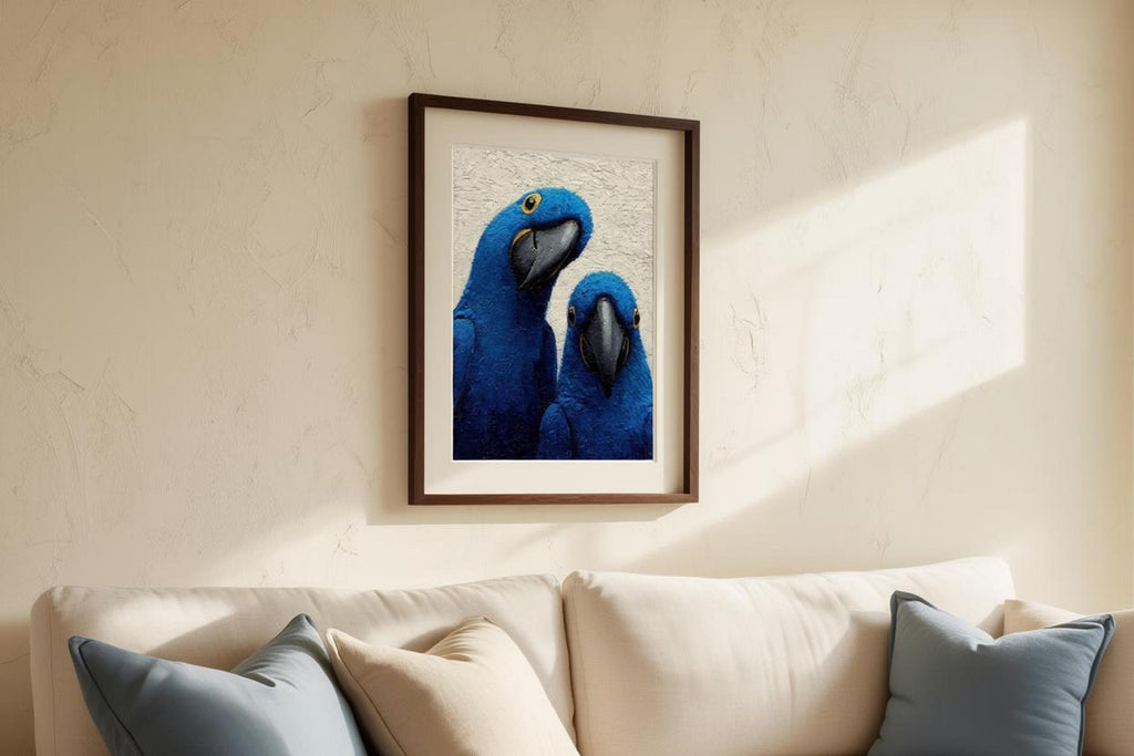 Framed blue macaw wall art above a couch with neutral pillows, warm afternoon light highlights texture