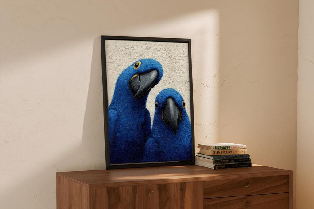 Framed blue macaw wall art propped on a wooden dresser, beige wall and a small decorative book beside it