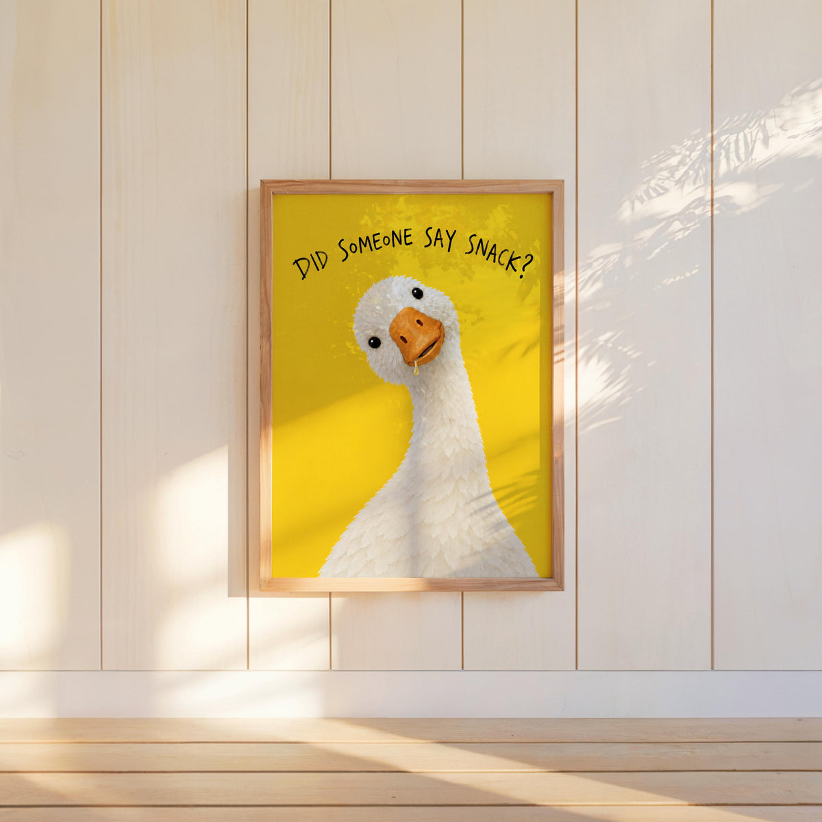 Framed funny kitchen poster hung on white paneled wall, bright yellow goose poster brings playful charm