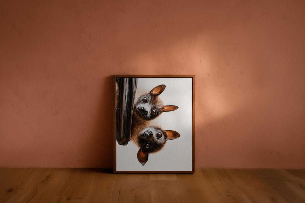 Small framed fruit bat art print against muted terracotta, cozy vignette, funny bat wall decor energy